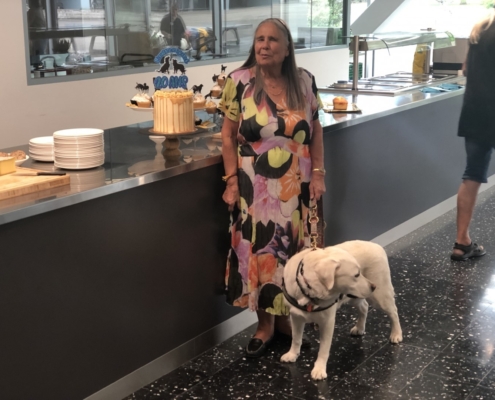 Une dame souriante aux côtés de son chien guide labrador, lors du 20ème anniversaire de l'Association L'Autre Regard.