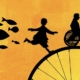 Silhouettes d’un enfant courant et d’un adulte en fauteuil roulant sur une grande roue, fond orange, poissons en vol.