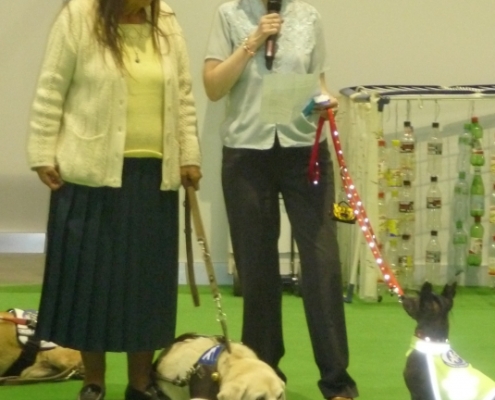 Deux dames avec leurs chiens d’assistance lors d’un événement éducatif sur les chiens guides à l’intérieur d’un salon.
