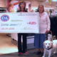 Remise d’un chèque de Fr. 4’000.– à l’association L’Autre Regard, au nom de C&A, en présence d’une dame avec son chien guide.
